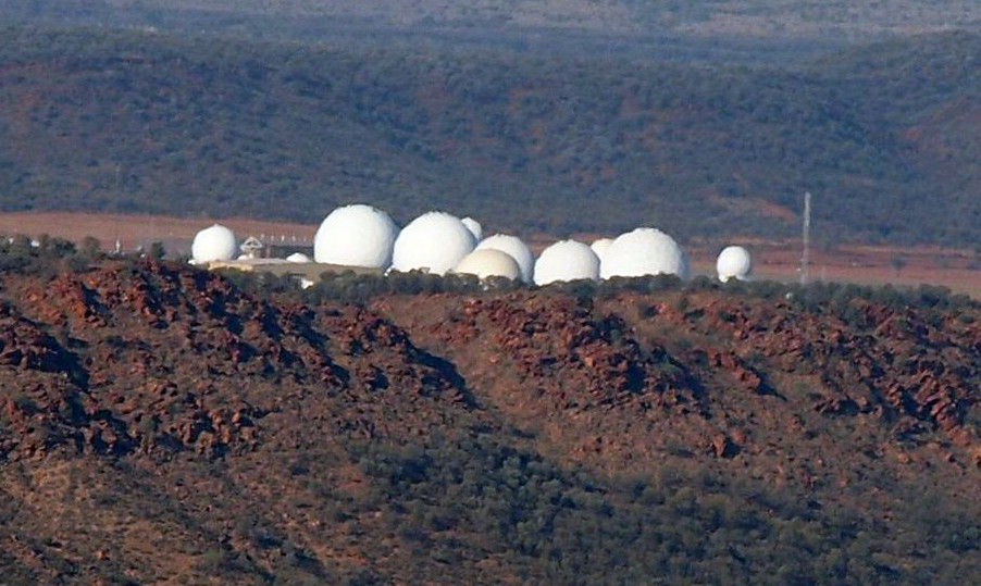 Aerial photo of Pine Gap Defence Base sitting on a flat plain between hills.